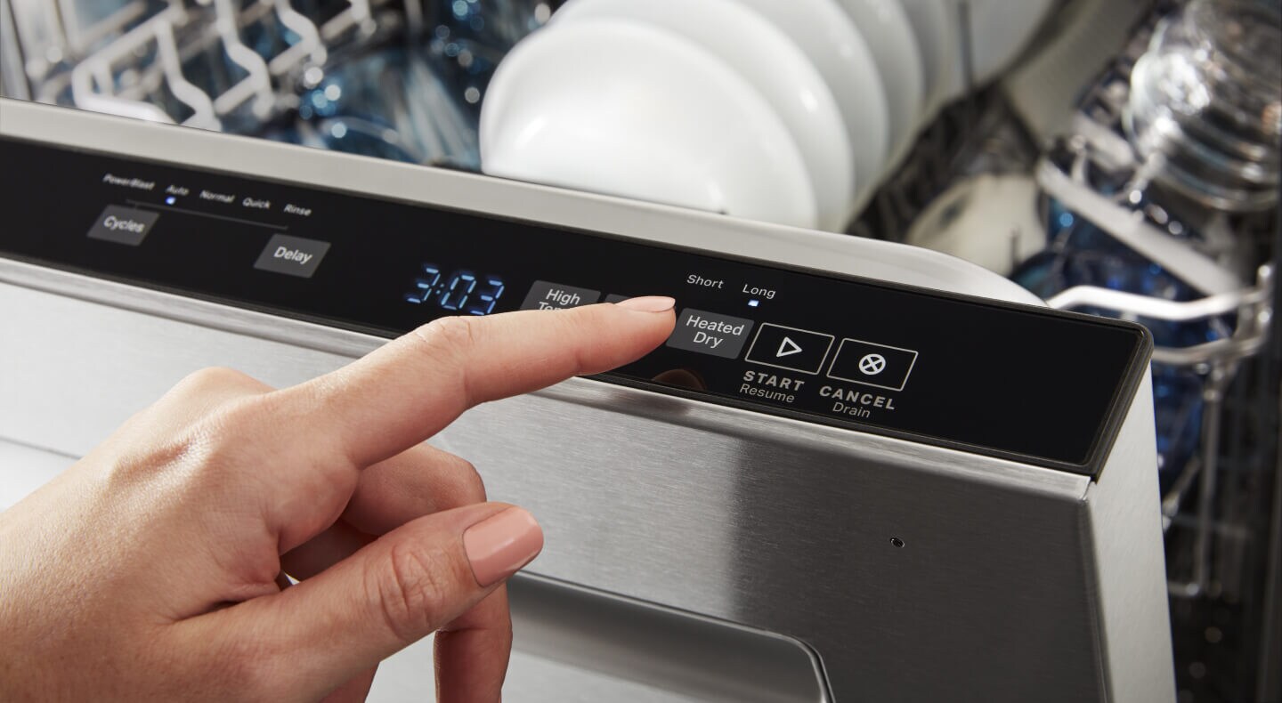 Person selecting settings on top control dishwasher