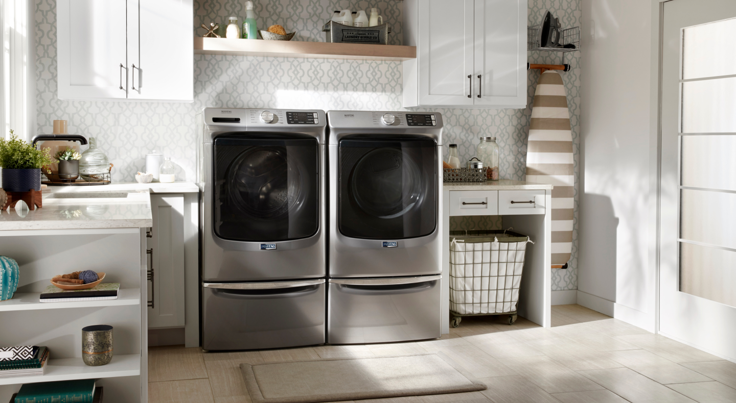 Maytag® front load washer and dryer set on laundry pedestals