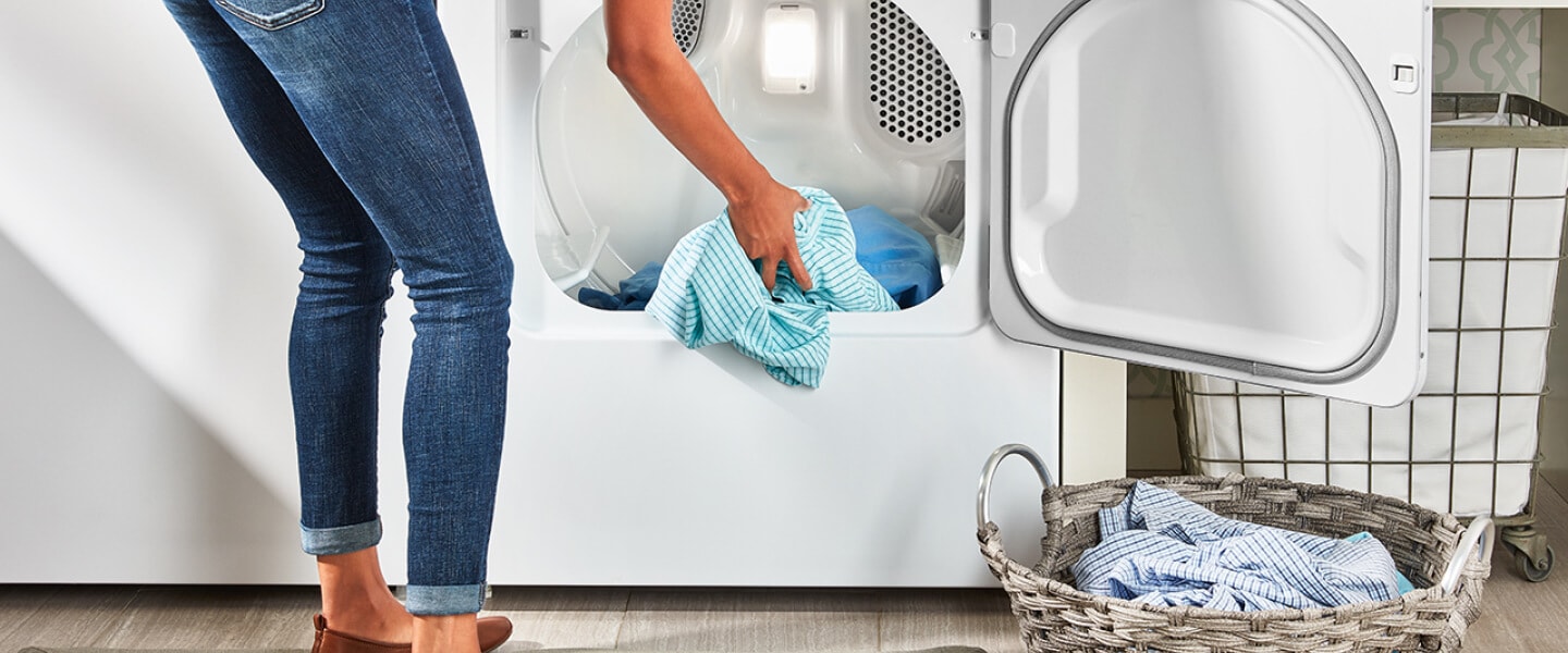 Person unloading dry laundry from a dryer Person unloading dry laundry from a dryer.