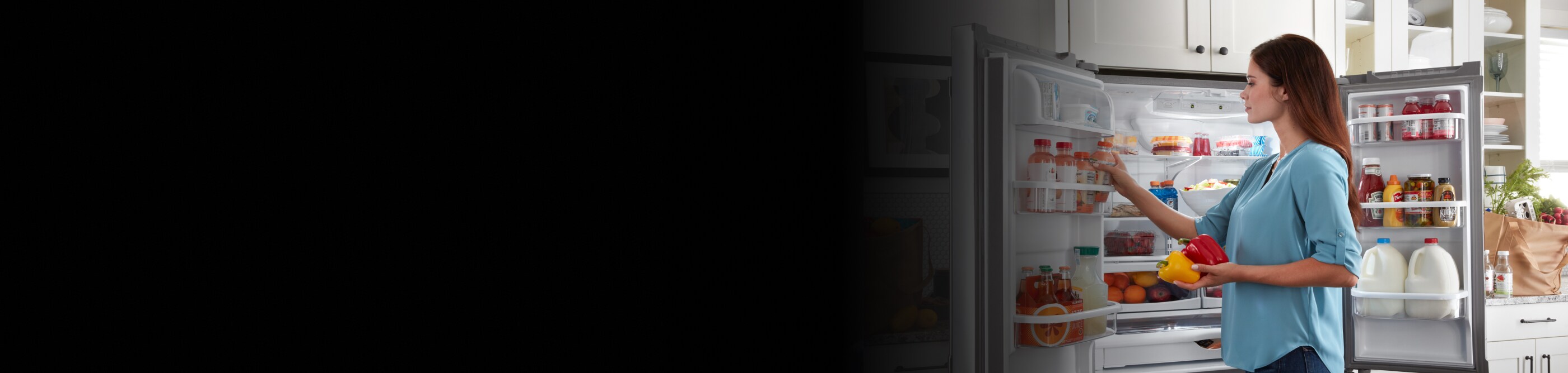 Woman loading drinks in the refrigerator door