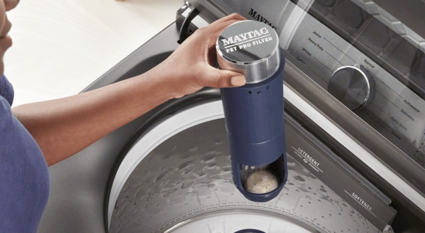 Person holding a Maytag® Pet Pro Filter Person holding a Maytag® Pet Pro Filter