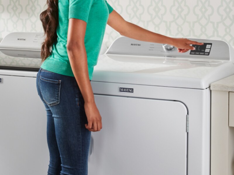 Person doing laundry in a laundry room Person doing laundry in a laundry room