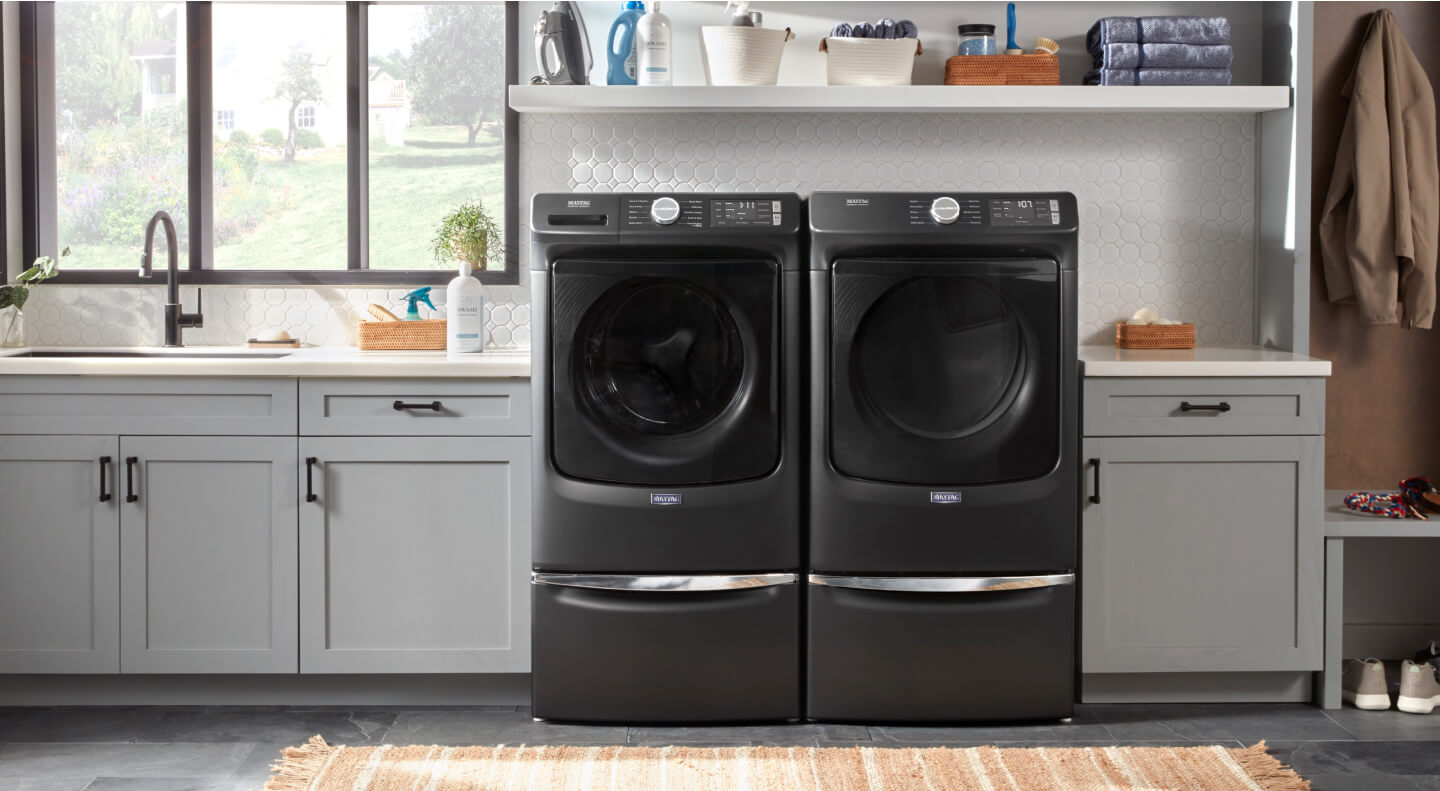 Black Maytag® front load washer and dryer pair in gray cabinetry