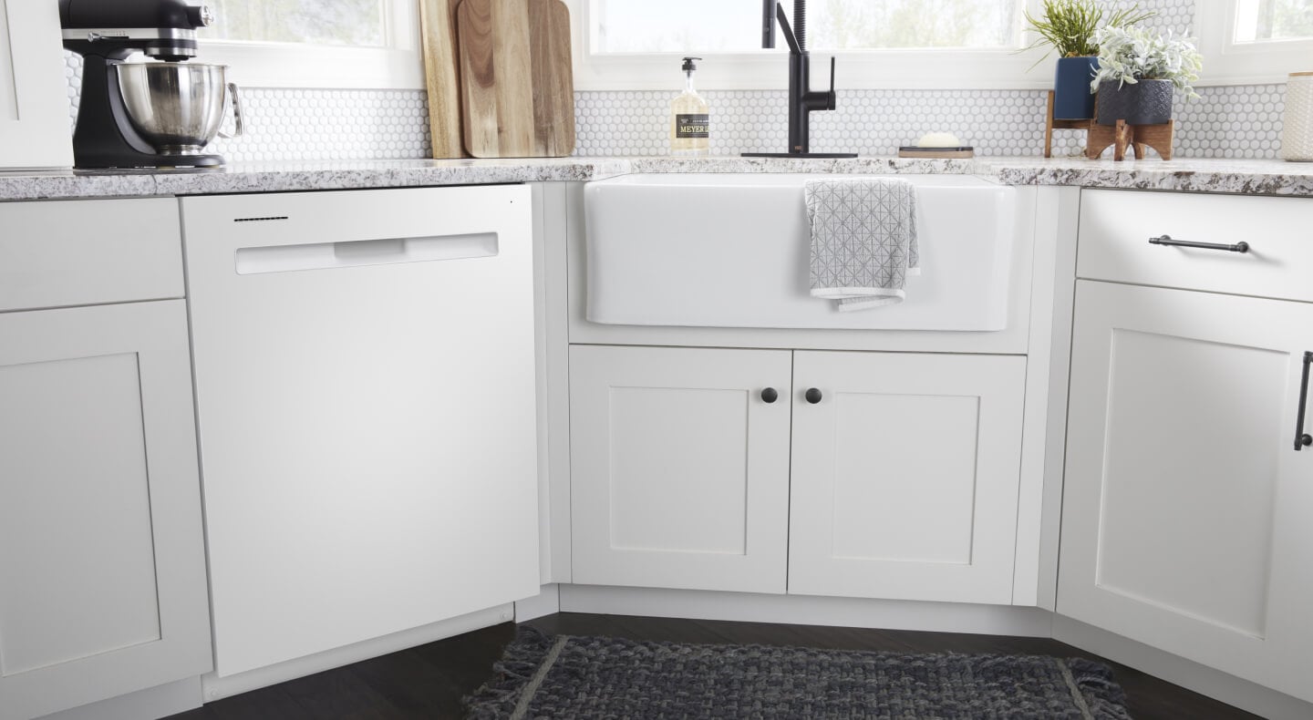 White Maytag® dishwasher with pocket handle in white cabinetry