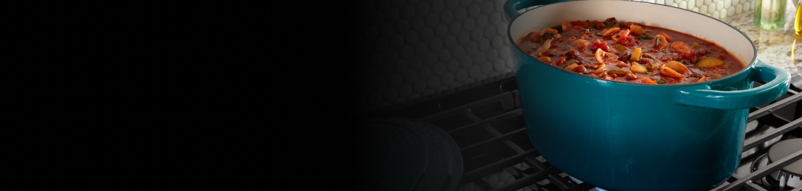 A dish of food simmering on a gas stovetop.