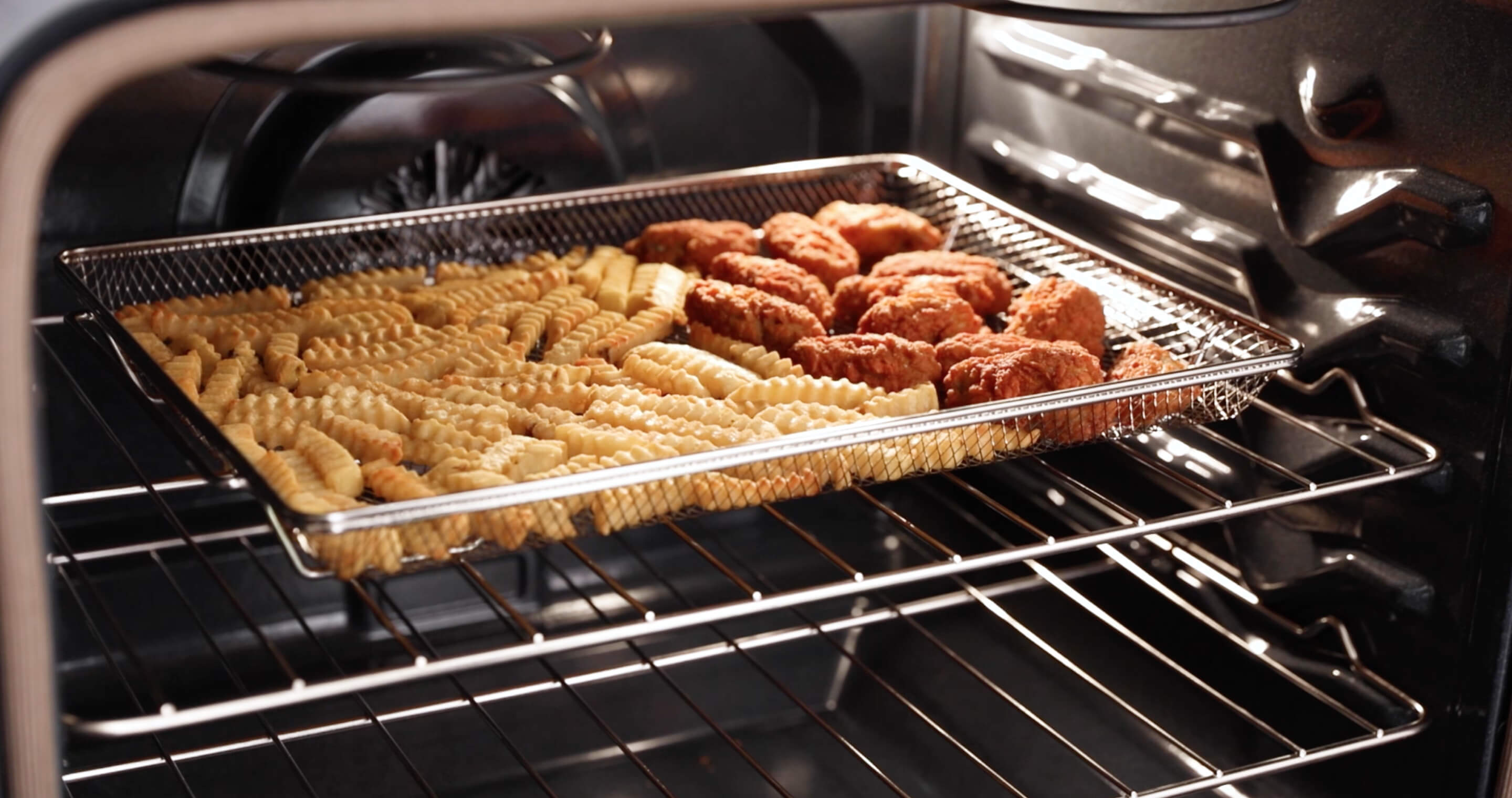 Fries and chicken wings in the dishwasher-safe air fry basket.