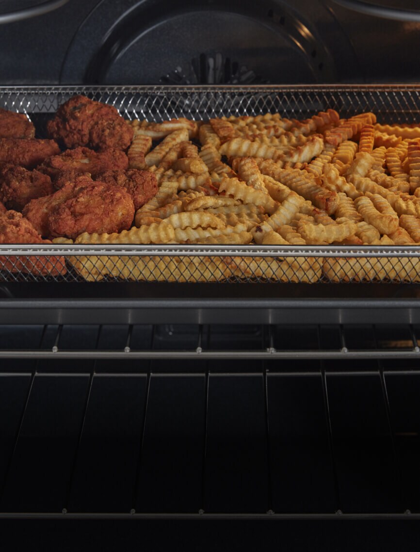 Chicken wings frying in the air fry basket.