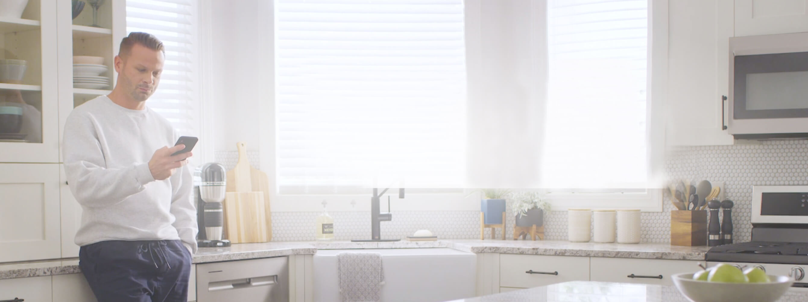 A person looking at their phone in the kitchen