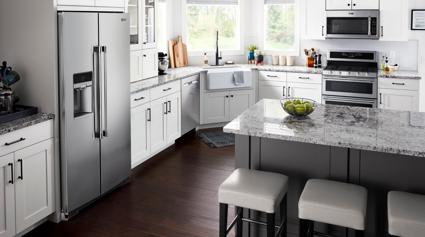 A counter-depth refrigerator placed inside a cabinet cutout.