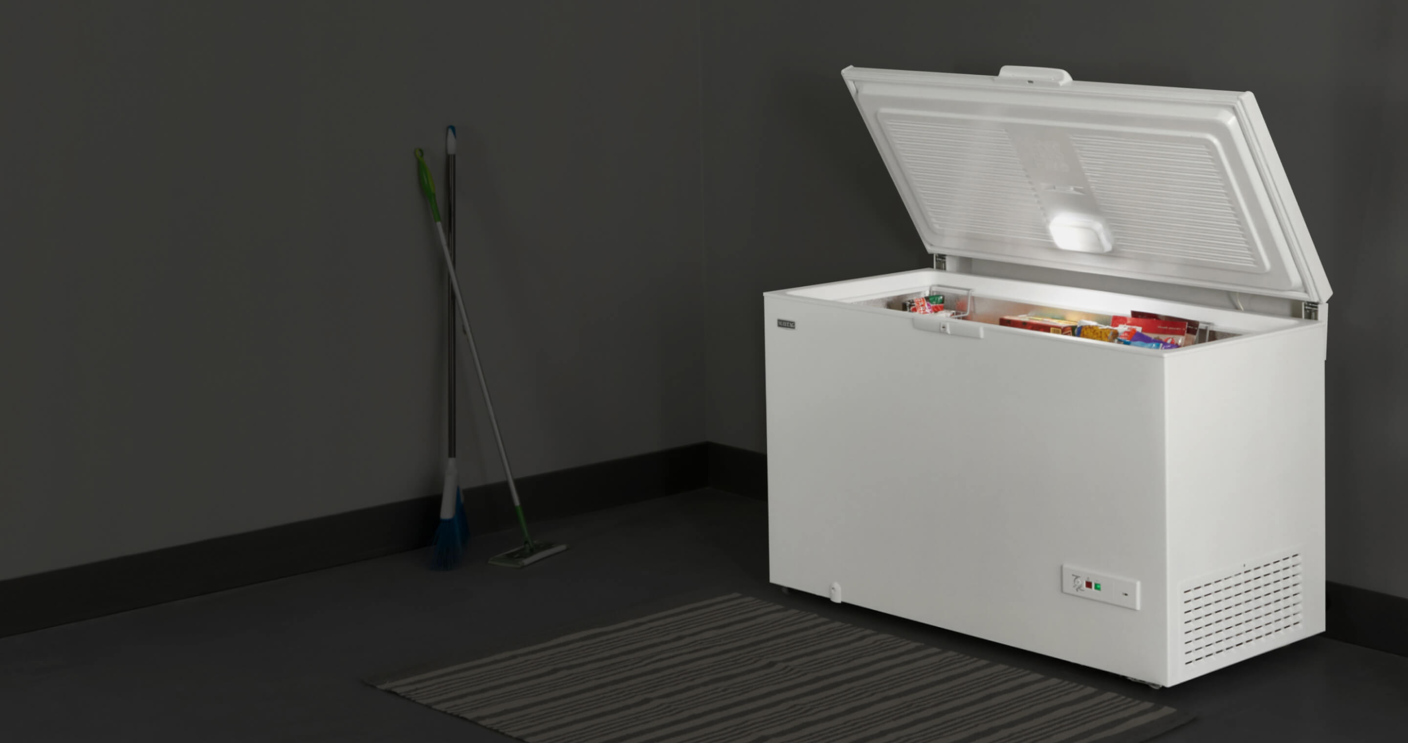 An open Maytag® chest freezer in a garage.