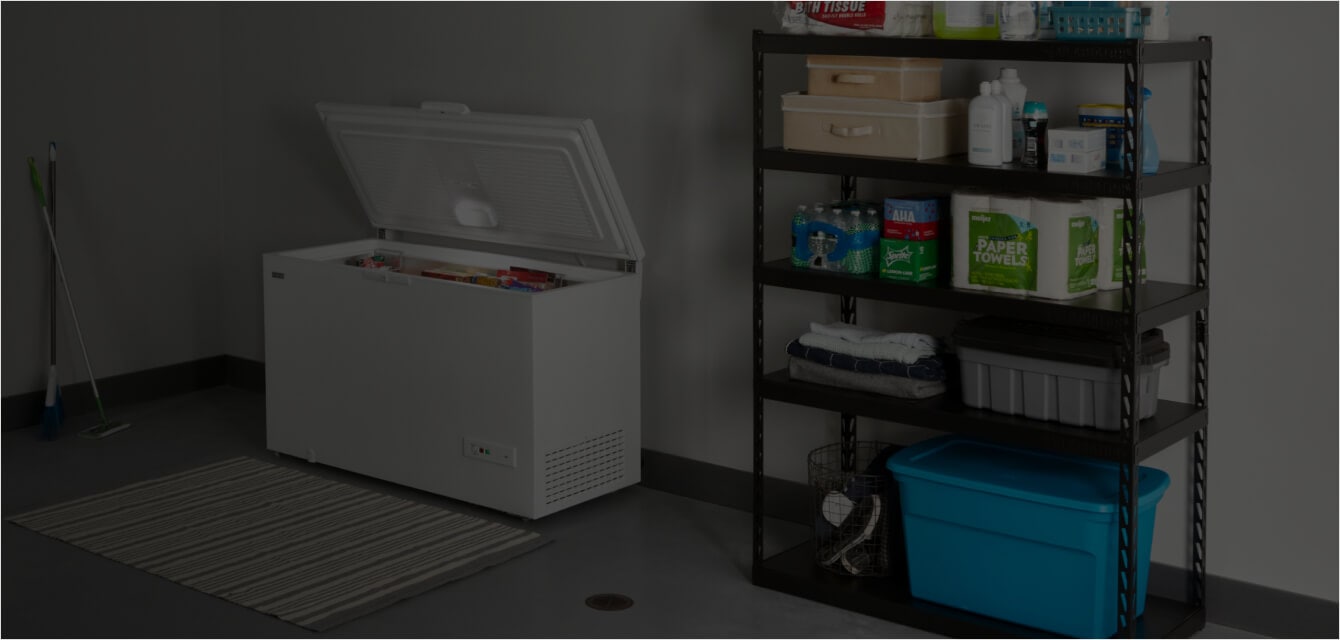 An open Maytag® chest freezer in a garage.