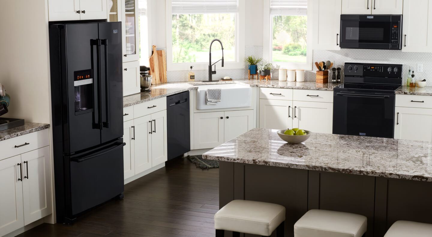 Black Maytag® French door refrigerator in kitchen with black appliance suite