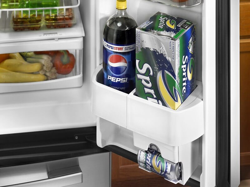 Bottled and canned sodas inside a refrigerator door