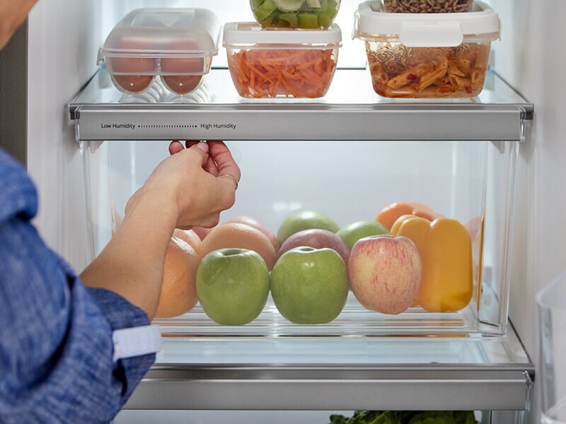 Person closing a refrigerator drawer