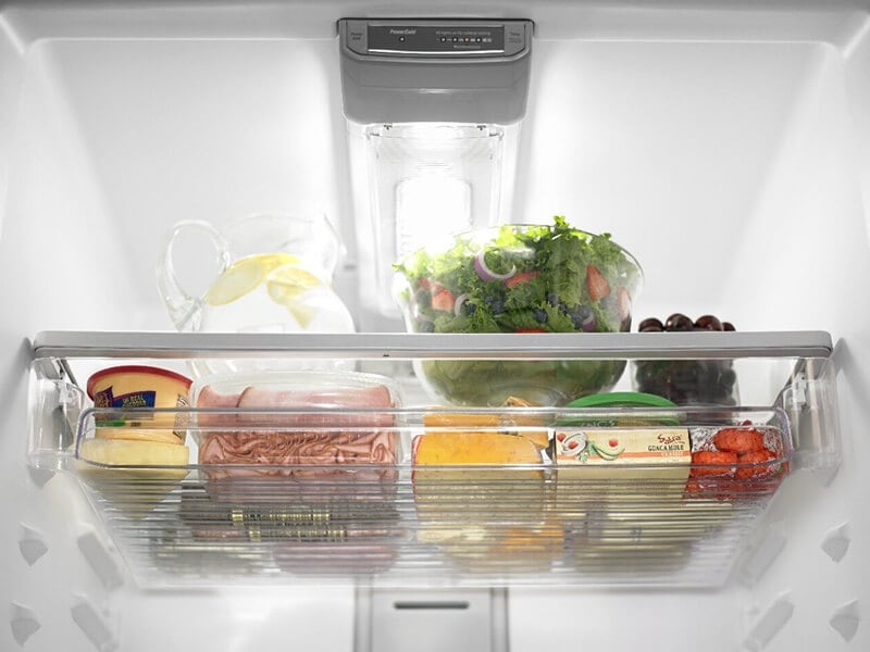 Produce, cheese, raw meat and dips inside a refrigerator