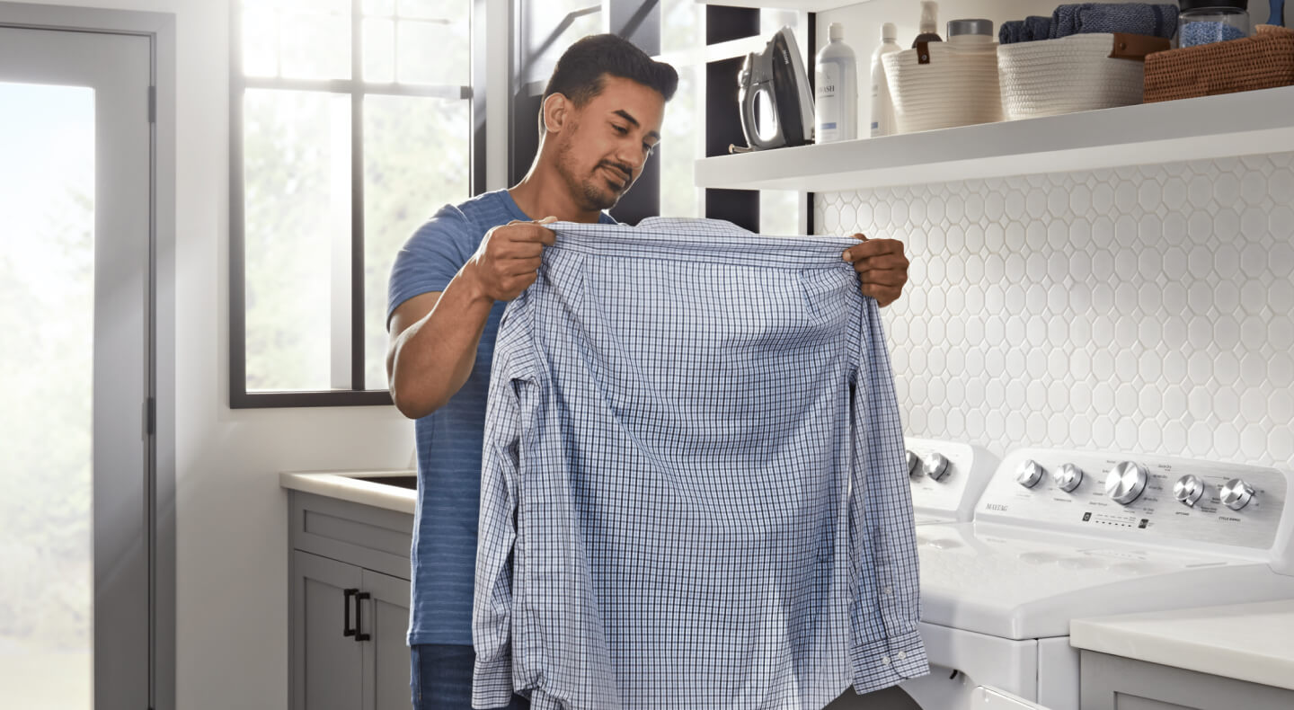 Person looking at freshly washed dress shirt Person looking at freshly washed dress shirt