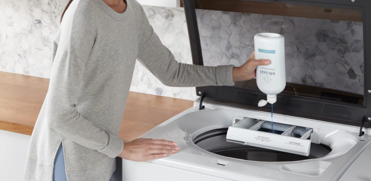 Person adding Swash® laundry detergent to the washing machine Person adding Swash® laundry detergent to the washing machine