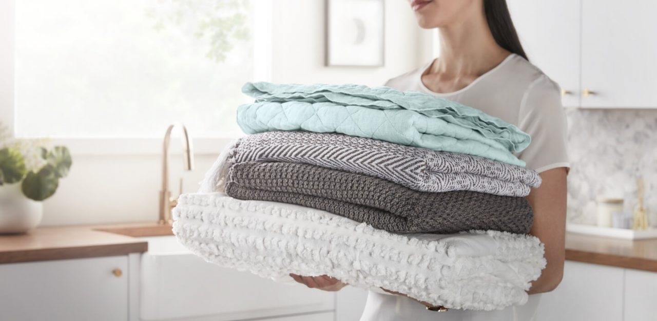 Person carrying a stack of folded towels Person carrying a stack of folded towels