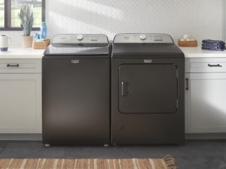 Top load washer and dryer set in a laundry room