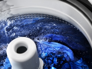 Washing machine open to show agitator cleaning clothes