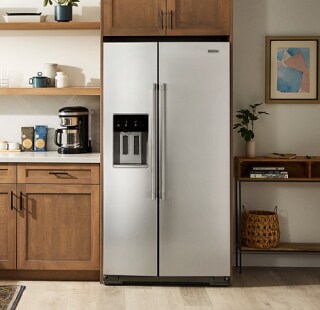 A refrigerator in a modern kitchen with brown cabinetry