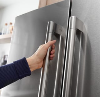 A person opening a refrigerator door