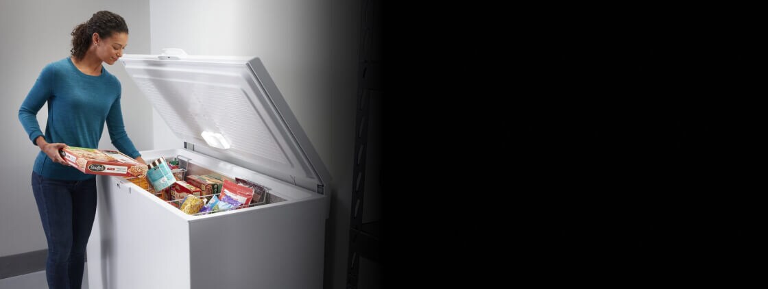 Person loading food into a chest freezer