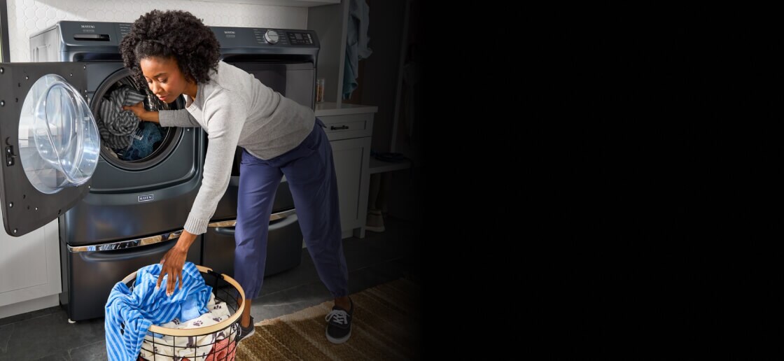 Person loading laundry into a Maytag® washer