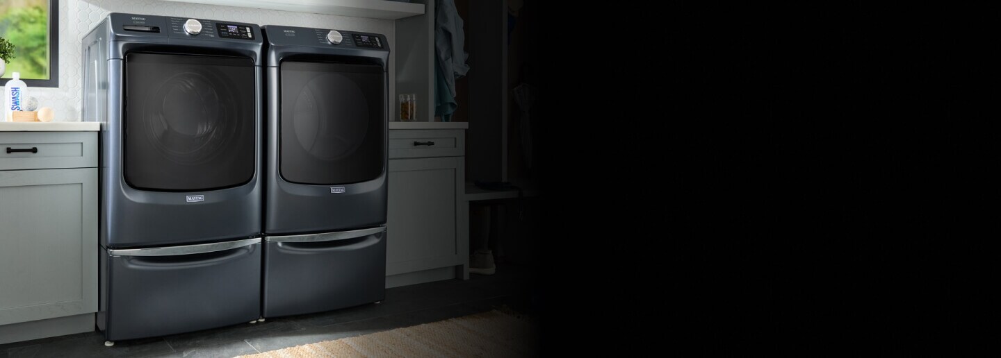 Maytag® front load washer and dryer set on laundry pedestals