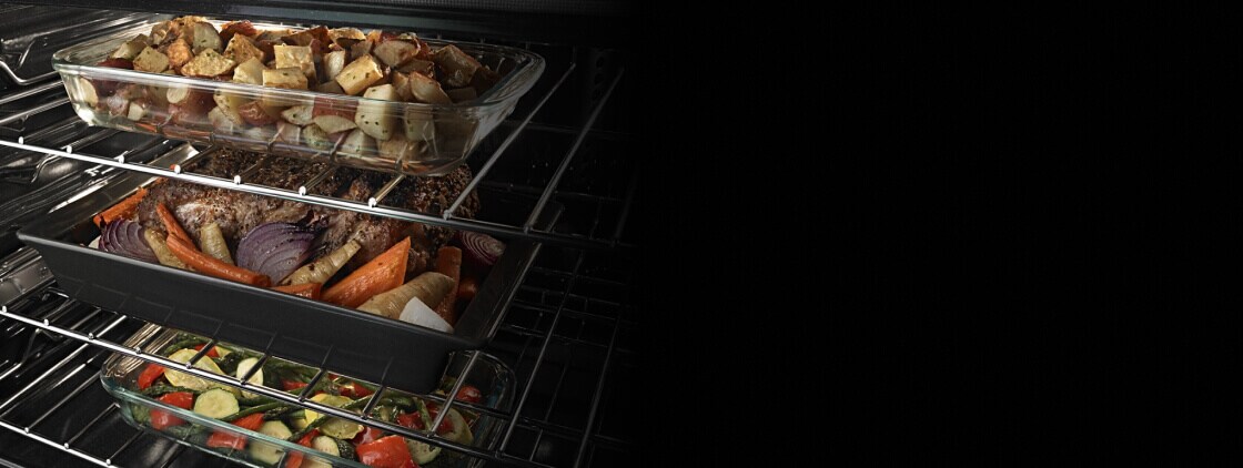 Three casserole dishes inside an oven