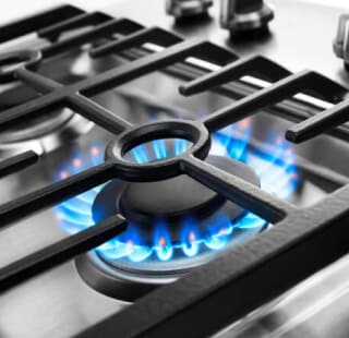 Blue flames simmering under cooktop grates