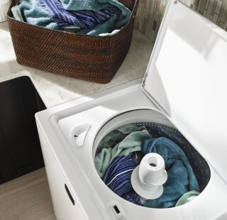 Open top load washing machine filled with laundry