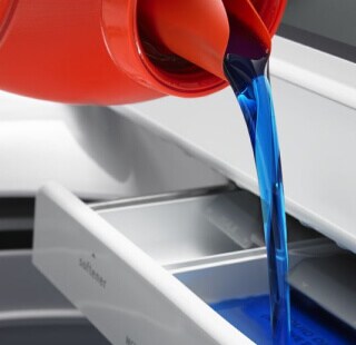 Laundry detergent being poured into a washing machine
