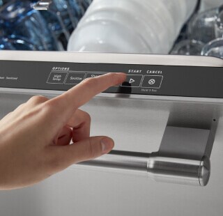 Person selecting a setting on a dishwasher control panel