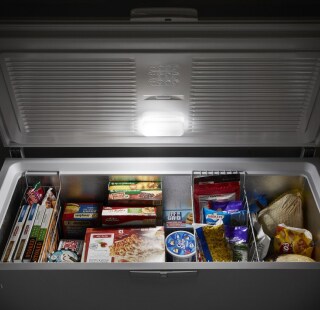 Open chest freezer filled with frozen food