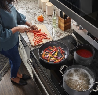 A person slicing vegetables and cooking
