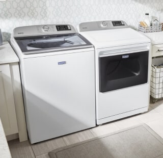 White Maytag® washer and dryer pair in a laundry room