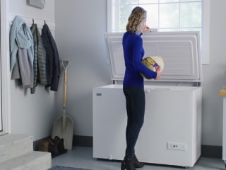 A person taking a turkey out of a chest freezer