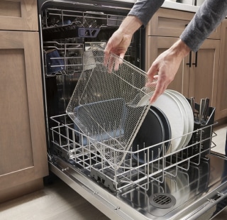 A person loading a dishwasher