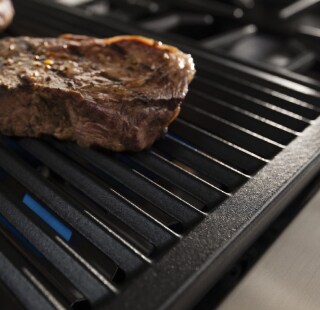 A steak searing on a stove