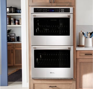 A double wall oven and brown cabinetry