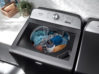 Colorful laundry soaking in a Maytag® washer
