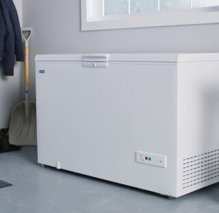 A white chest freezer in a garage