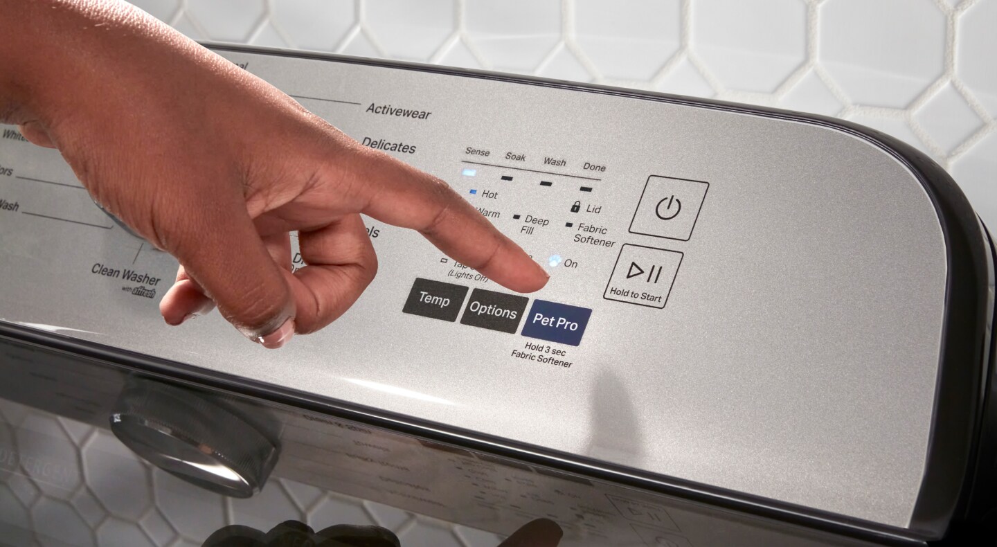 A person selecting the Pet Pro setting on a Maytag® washer. A person selecting the Pet Pro setting on a Maytag® washer.