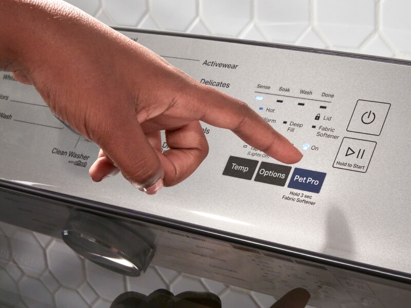 A person selecting the Pet Pro setting on a Maytag® washer. A person selecting the Pet Pro setting on a Maytag® washer.