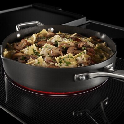 A close-up of a pan of pasta cooking on a Maytag® cooktop
