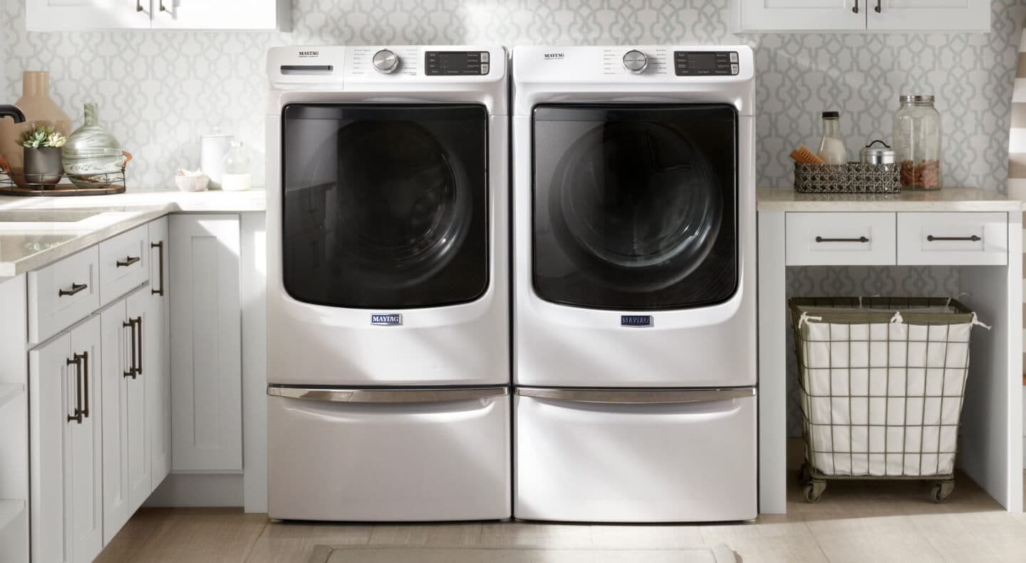 White Maytag® front load washer and dryer pair on pedestals