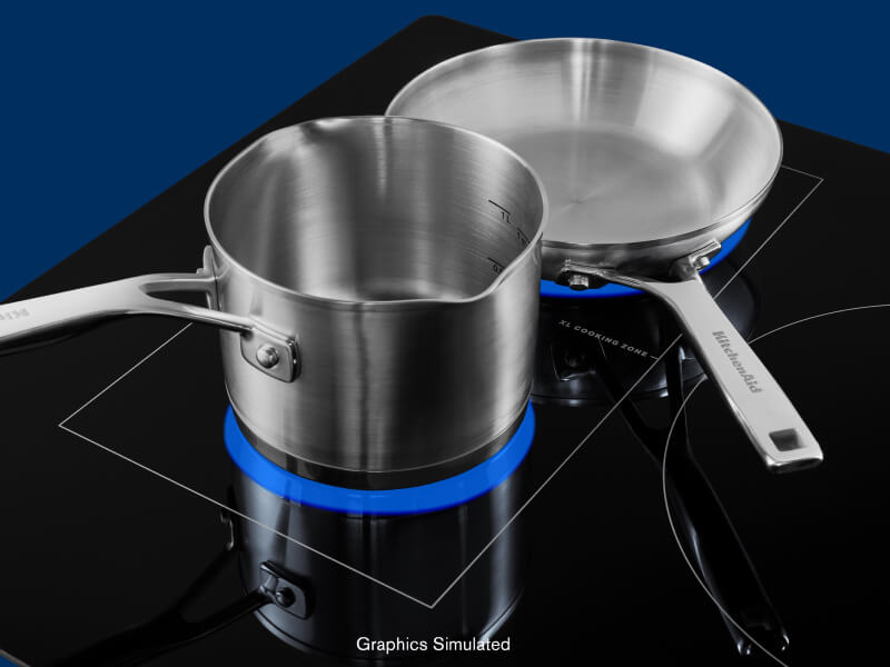 Stainless steel stock pot and frying pan on induction cooktop elements