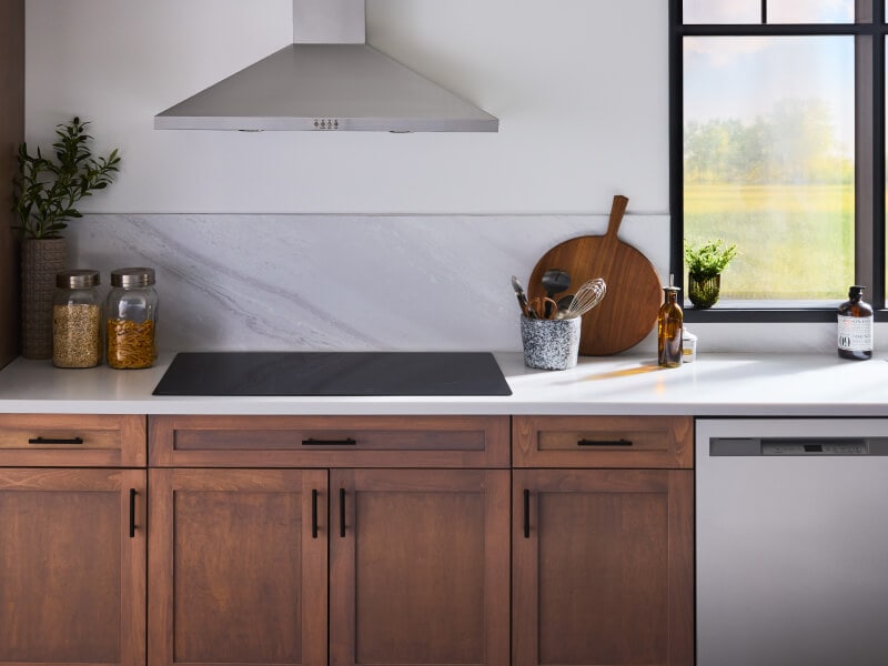 Induction cooktop installed above rich brown cabinetry