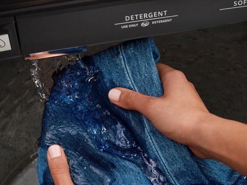 Hands pre-treating denim with built-in water faucet Hands pre-treating denim with built-in water faucet